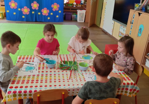 Dzieci przy stoliku podczas malowania farbami rosnącymi