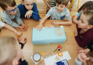 Przedszkolaki wspólnie tworzą instrument z niepotrzebnych materiałów