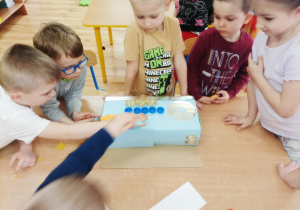 Przedszkolaki wspólnie tworzą instrument z niepotrzebnych materiałów