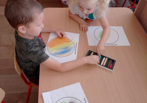 Dzieci projektują wygląd kropki na papierze.