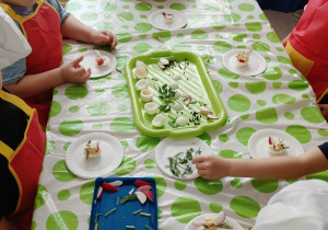 dzieci ozdabiają ugotowane jajka