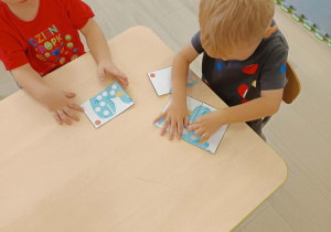 Chłopcy układają puzzle.