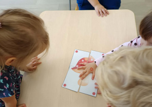 Przedszkolaki układają puzzle.