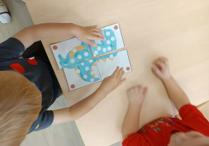 Chłopcy układają puzzle.