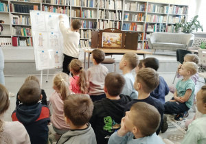Dzieci siedzą chłopiec przyczepia obrazek
