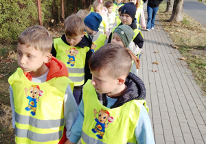 Dzieci idą w kamizelka odblaskowych