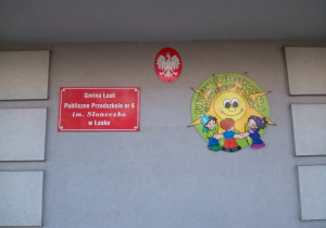 Widok na znajdujący się przed wejściem do przedszkola szyldy z nazwą i logo przedszkola